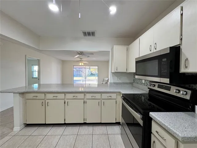 a kitchen with a sink stove top oven and cabinets