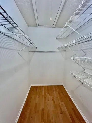 a view of an empty room with a window and a ceiling fan