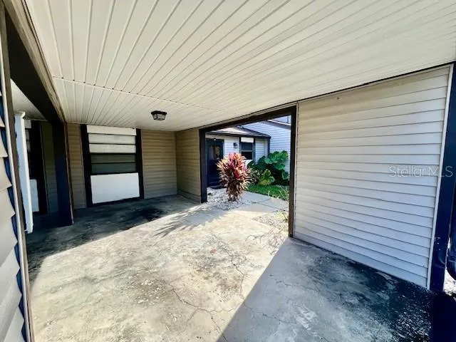 a view of a hallway with wooden floor and a bathroom