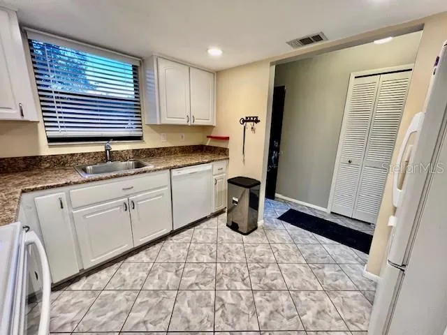 a kitchen with white cabinets and white appliances