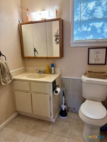 a bathroom with a toilet sink and mirror