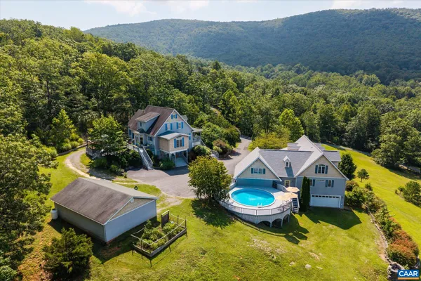 an aerial view of a house with swimming pool and a yard