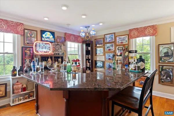 a kitchen with stainless steel appliances granite countertop wooden cabinets a sink a stove a dining table and chairs