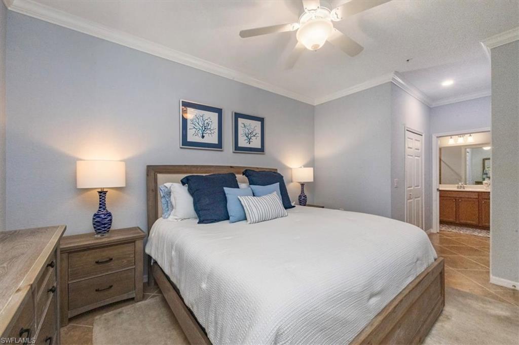 9566 Trevi Court, Unit 4942 Naples, FL 34113 - Photo 13 of 31 a bedroom with a bed and a chandelier