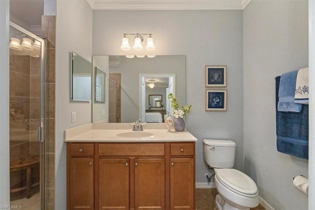 9566 Trevi Court, Unit 4942 Naples, FL 34113 - Photo 14 of 31 a bathroom with a sink a toilet a mirror and shower