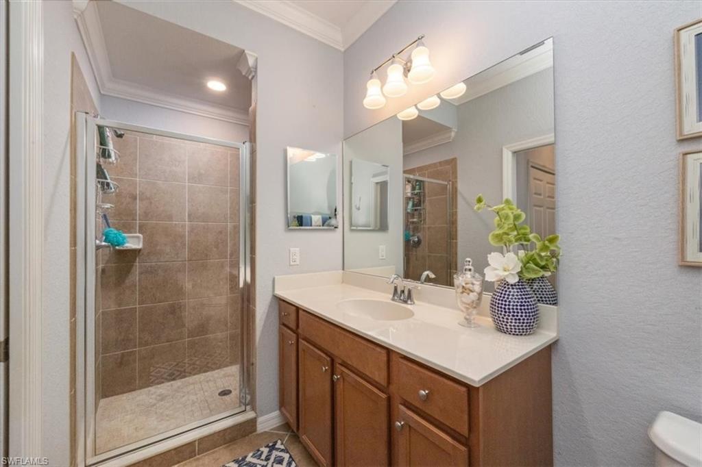 9566 Trevi Court, Unit 4942 Naples, FL 34113 - Photo 15 of 31 a bathroom with a sink shower and a mirror