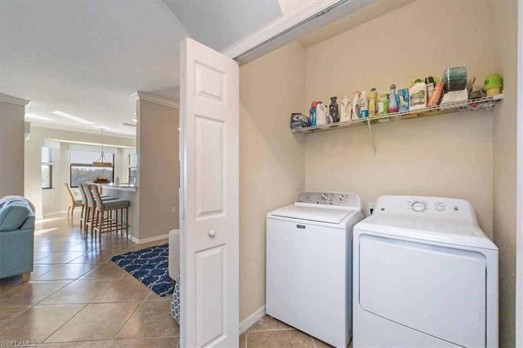 9566 Trevi Court, Unit 4942 Naples, FL 34113 - Photo 19 of 31 a view of washer and dryer with kitchen in the background