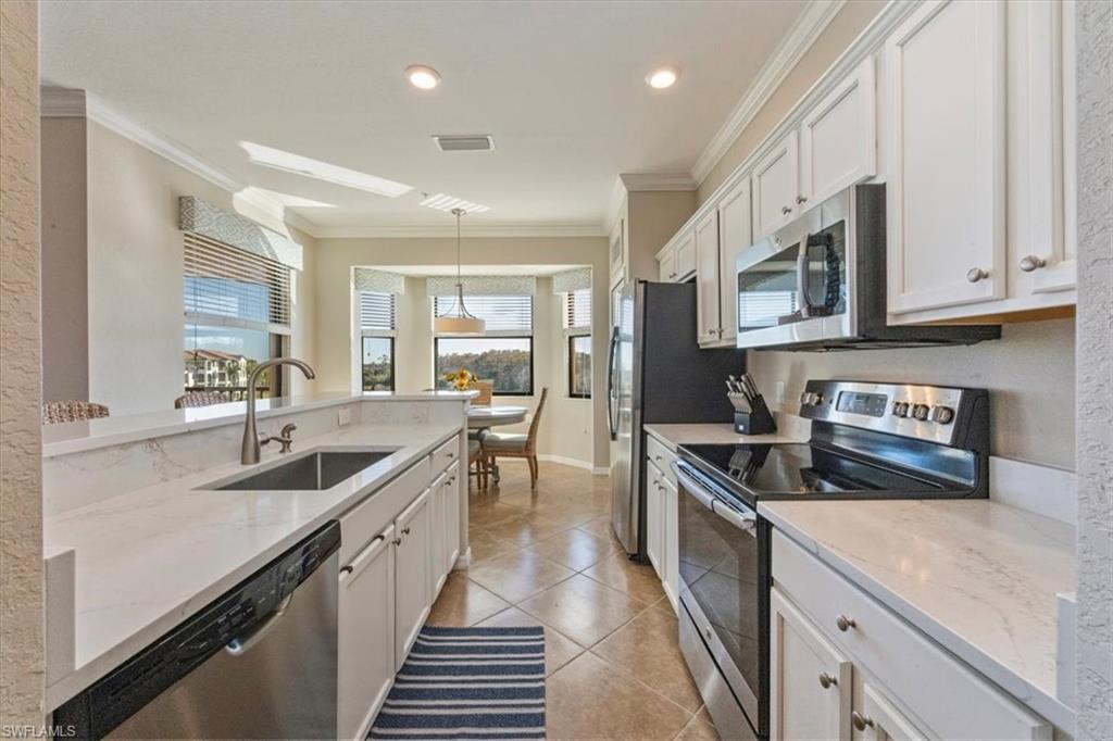 9566 Trevi Court, Unit 4942 Naples, FL 34113 - Photo 7 of 31 a kitchen with granite countertop a sink and stove top oven