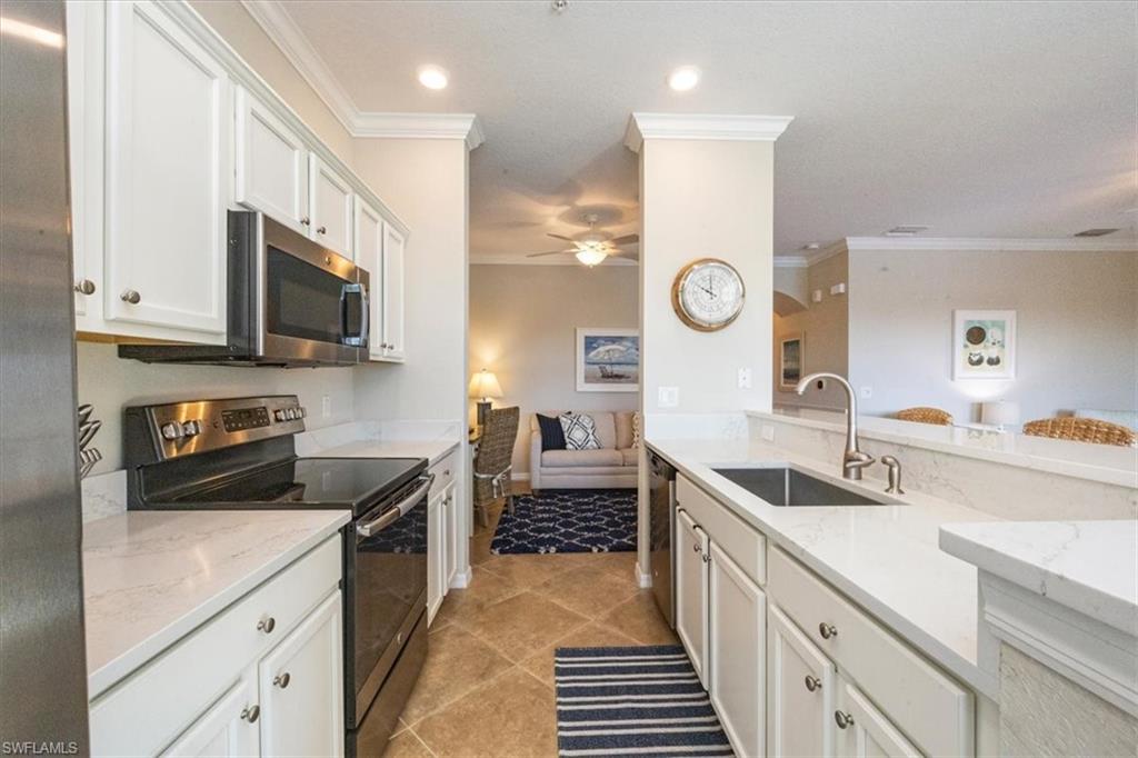 9566 Trevi Court, Unit 4942 Naples, FL 34113 - Photo 8 of 31 a kitchen with a sink stove and cabinets