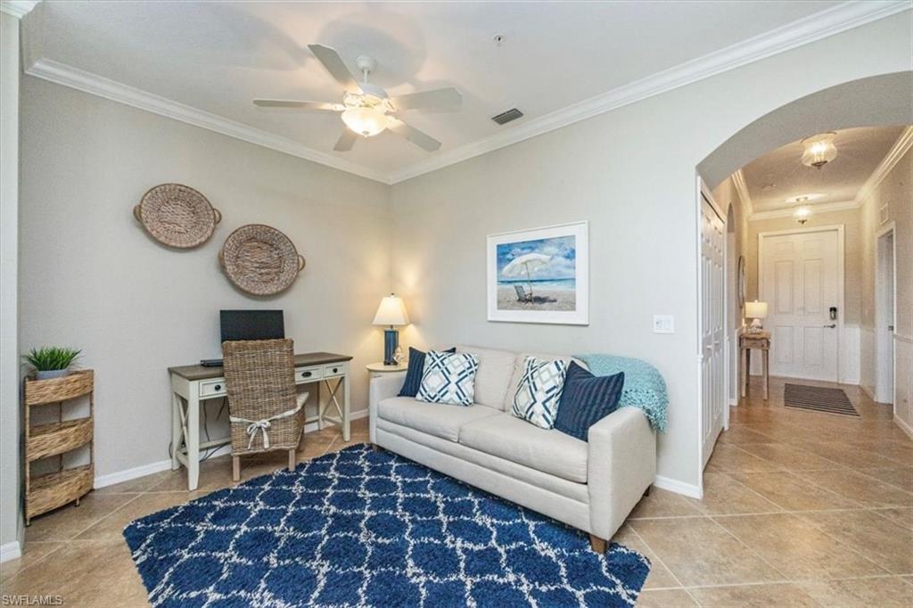 9566 Trevi Court, Unit 4942 Naples, FL 34113 - Photo 10 of 31 a living room with furniture a clock on wall and a window