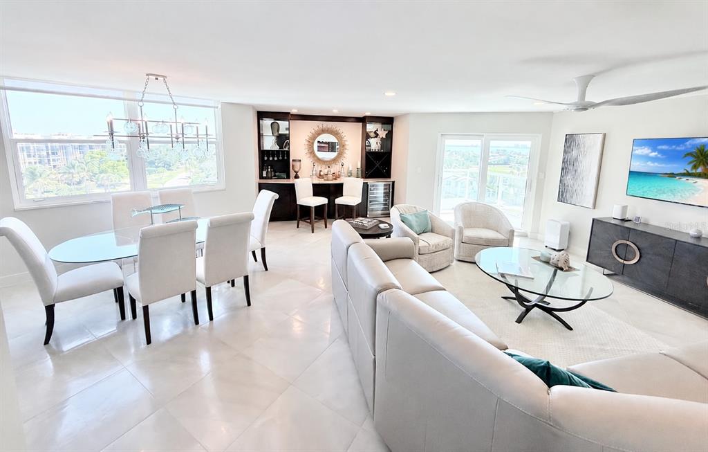 1050 Longboat Club Road, Unit 803 Longboat Key, FL 34228 - Photo 3 of 39 a living room with furniture a dining table and a floor to ceiling window