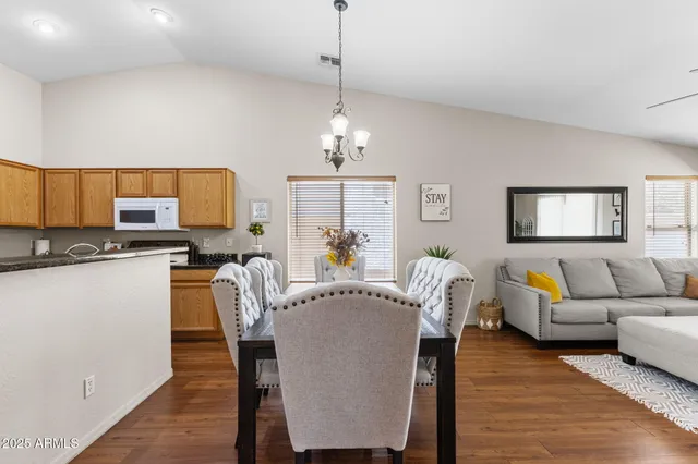a living room with furniture a dining table and a chandelier