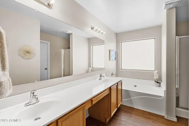 a bathroom with a tub double sink and mirror