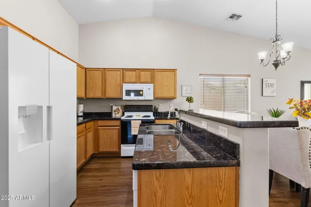 a kitchen with stainless steel appliances granite countertop a sink a stove and a refrigerator