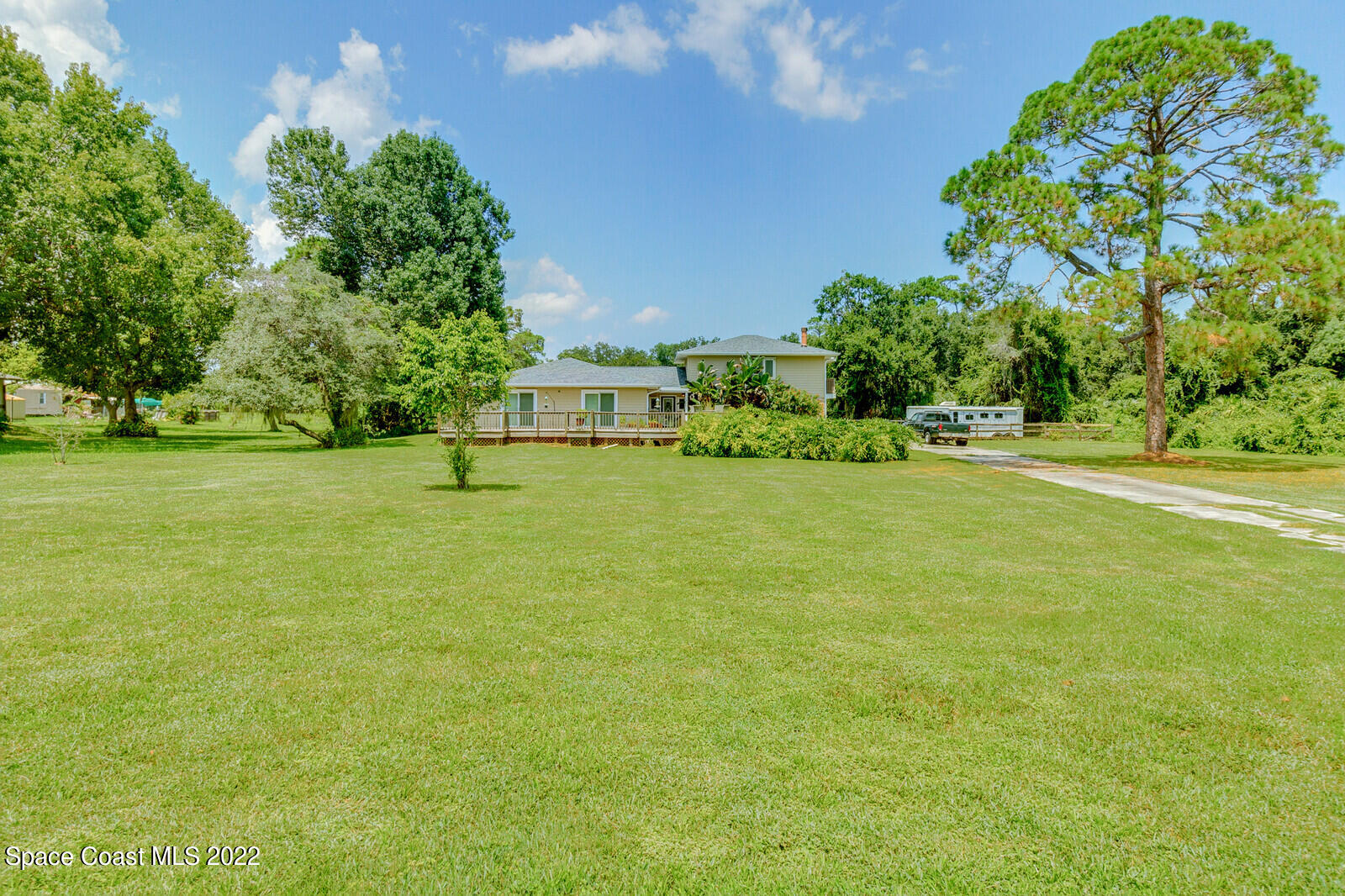 3600 Grant Line Road Mims, FL 32754 - Photo 3 of 54 a view of a green field with lawn chairs under an umbrella