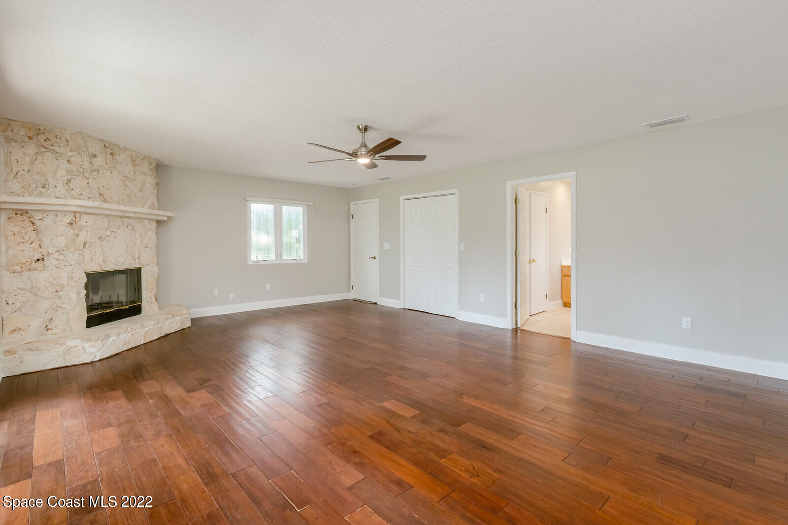 3600 Grant Line Road Mims, FL 32754 - Photo 31 of 54 an empty room with wooden floor and fireplace