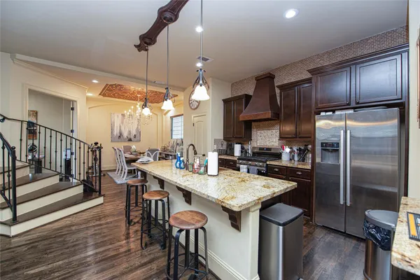 a kitchen with granite countertop a sink appliances and wooden floor