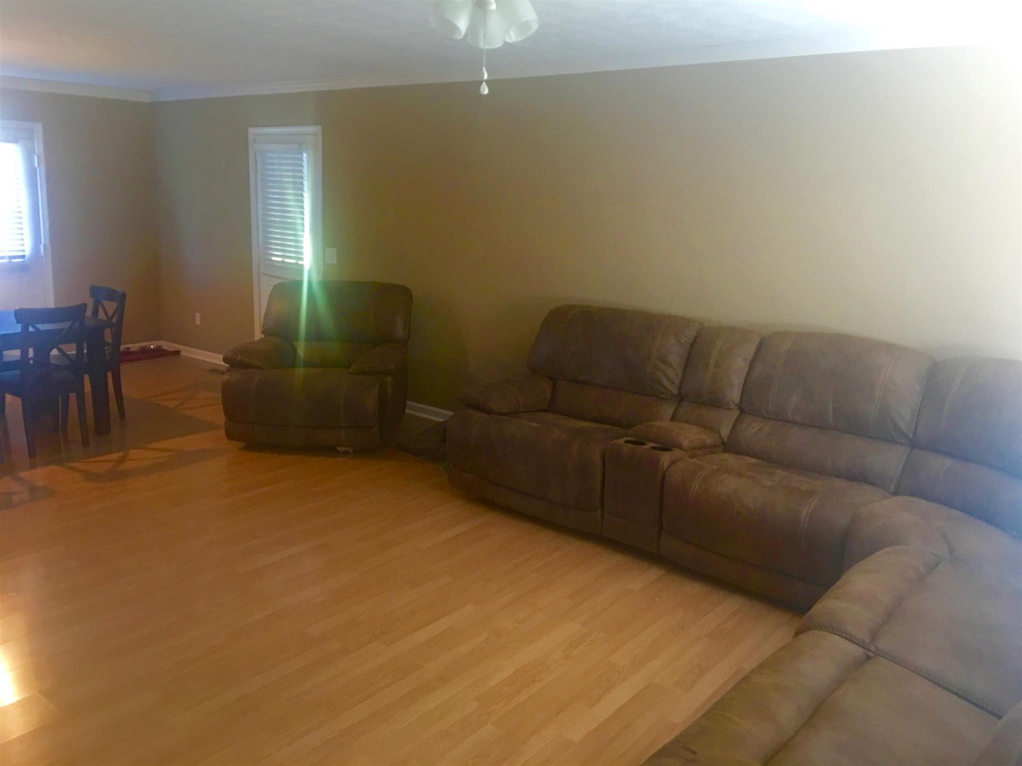 197 T G T Road Portland, TN 37148 - Photo 5 of 6 a living room with furniture and a dining table with chandelier