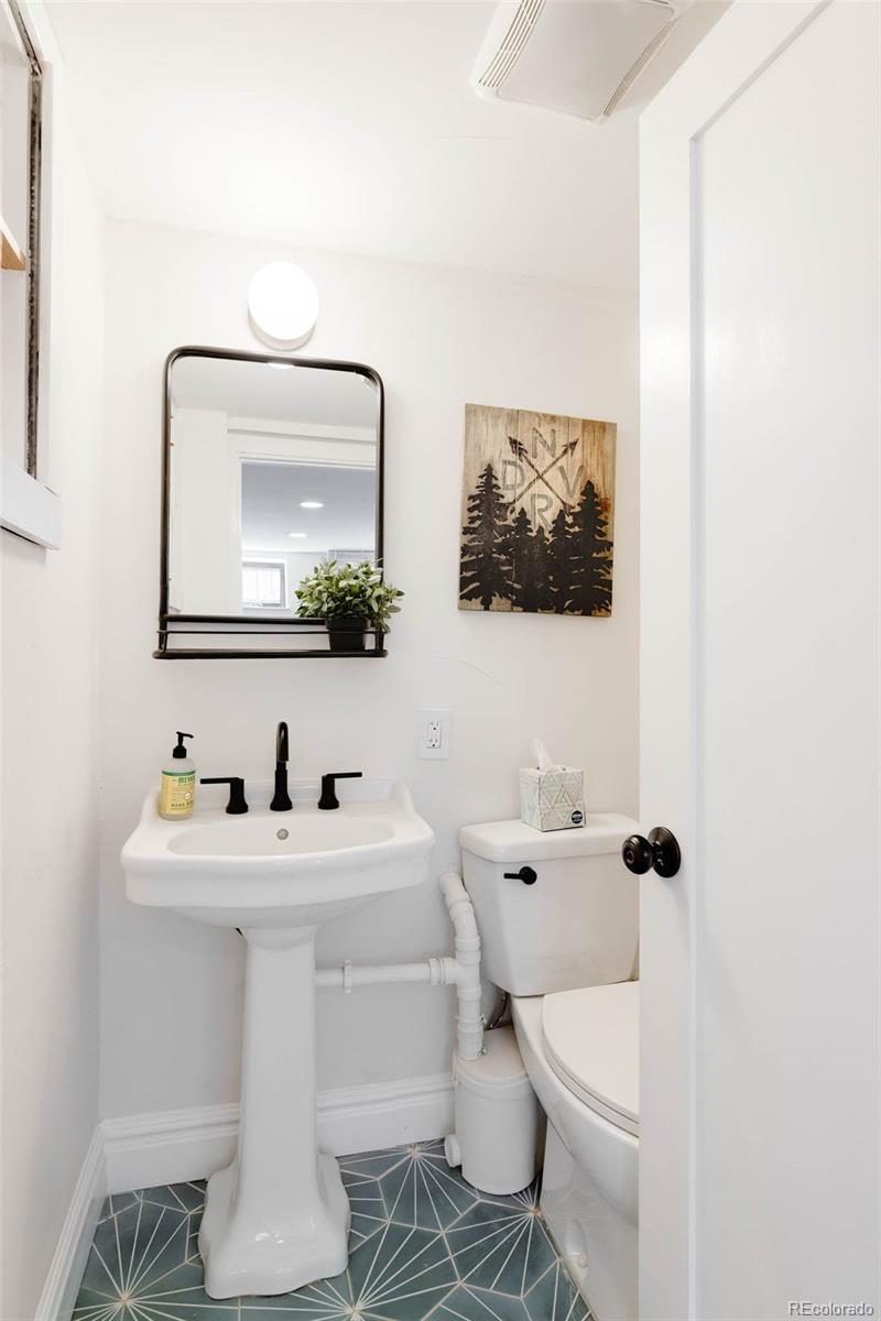 1058 Jackson Street Denver, CO 80206 - Photo 21 of 24 a bathroom with a toilet sink and mirror