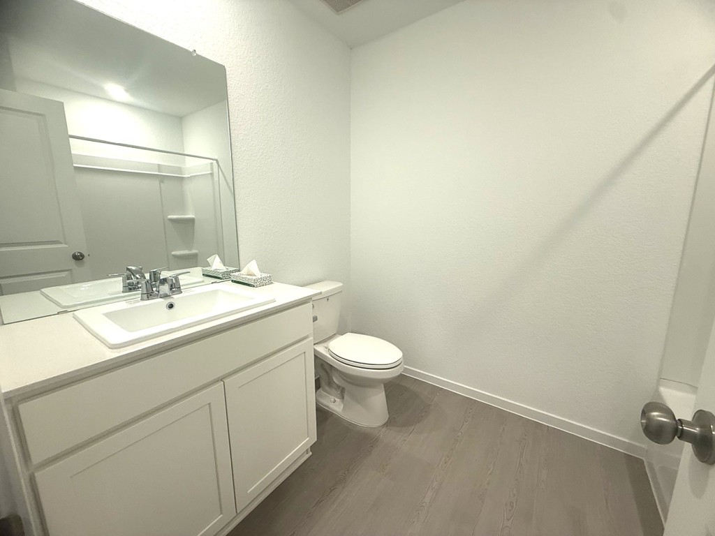 1520 Sunset Ridge Drive Conroe, TX 77306 - Photo 3 of 11 a bathroom with a toilet a sink and mirror
