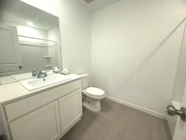 a bathroom with a toilet a sink and mirror