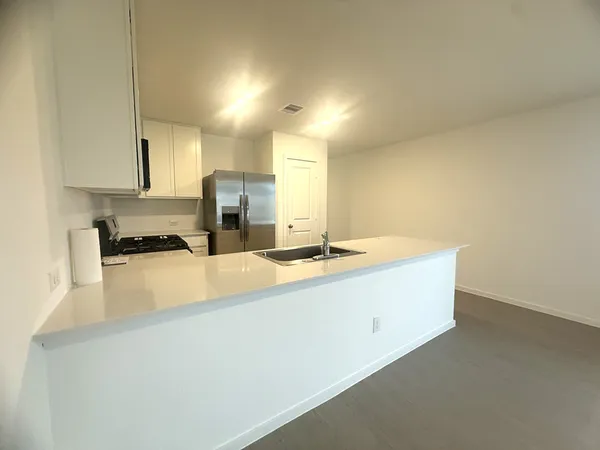 a large white kitchen with a sink and a stove top oven