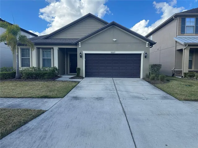 front view of a house with a yard and garage
