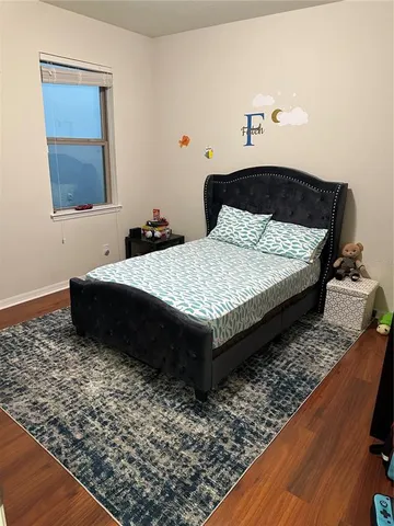 a bedroom with a bed rug and wooden floor
