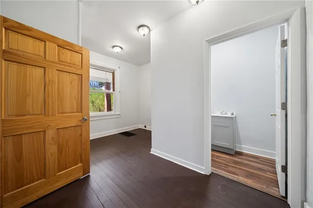 a view of empty room with wooden floor