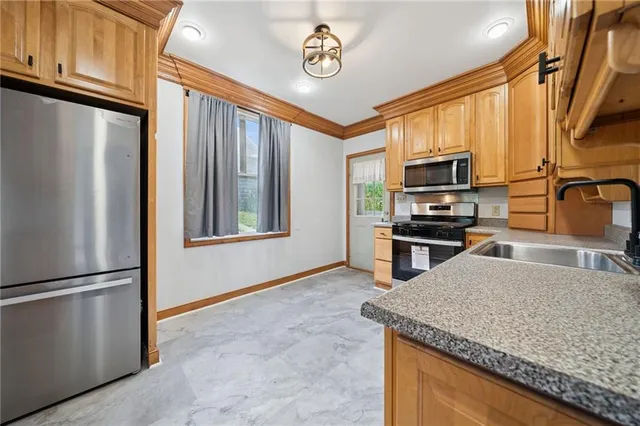 a kitchen with stainless steel appliances granite countertop a sink a stove and a refrigerator