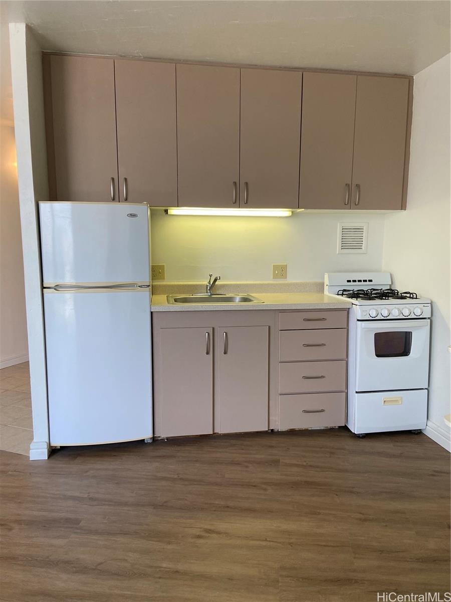750 Amana Street, Unit 1602 Honolulu, HI 96814 - Photo 3 of 8 a kitchen with a refrigerator a stove a sink and cabinets