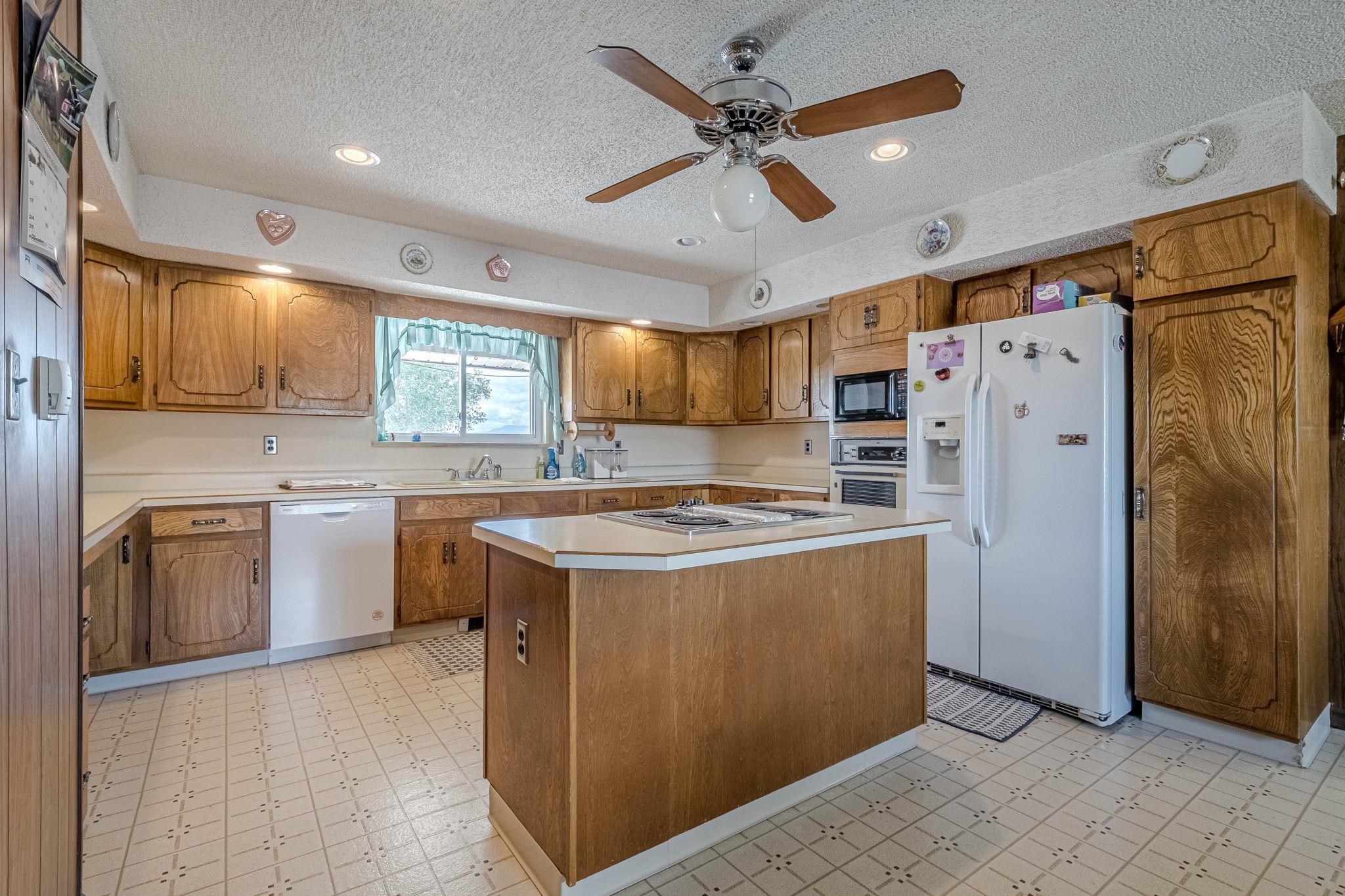 1176-17 17 1/2 Road Fruita, CO 81521 - Photo 26 of 42 a kitchen with stainless steel appliances granite countertop a stove a refrigerator a sink and dishwasher with white cabinets