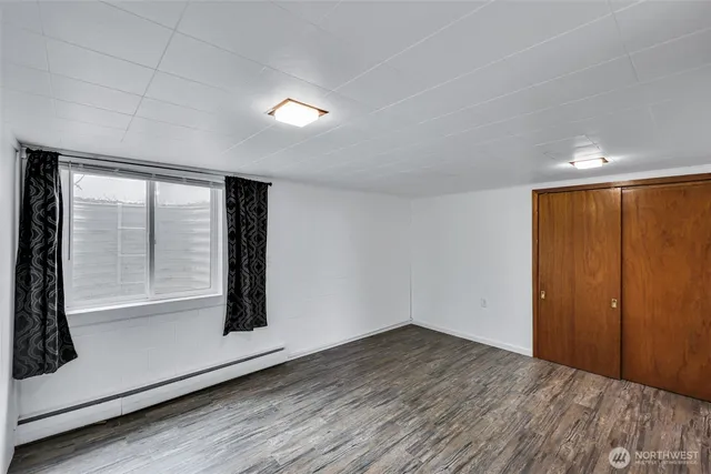 an empty room with wooden floor and door