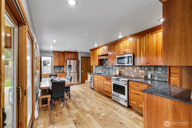 a kitchen with stainless steel appliances granite countertop sink stove top oven and cabinets