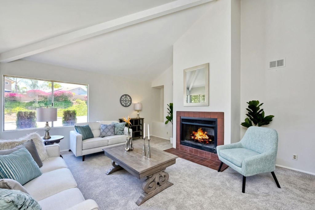 a living room with furniture fireplace and a large window