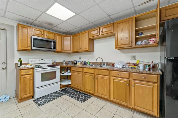 a kitchen with granite countertop a sink stove and refrigerator