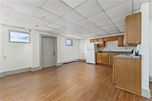 an empty room with wooden floor and cabinet