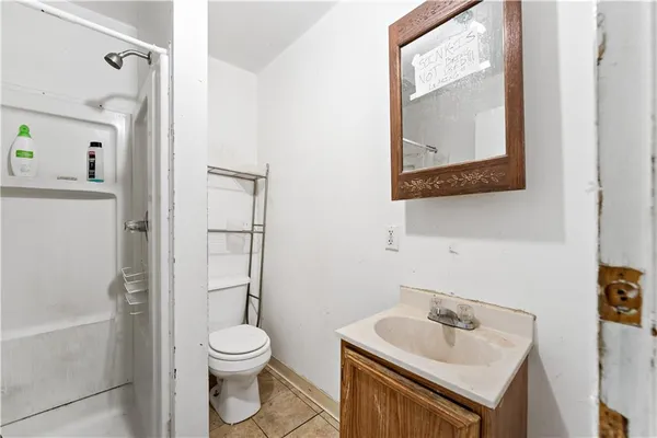 a bathroom with a toilet sink vanity and mirror