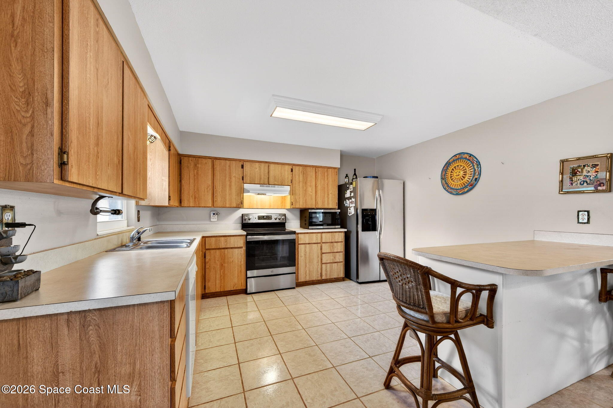 6033 Palm Street Mims, FL 32754 - Photo 13 of 44 a kitchen with a sink a stove and chairs