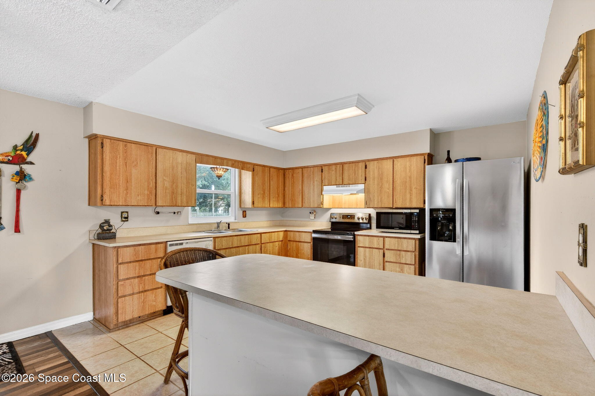 6033 Palm Street Mims, FL 32754 - Photo 14 of 44 a kitchen with a refrigerator a sink a stove a dining table and chairs