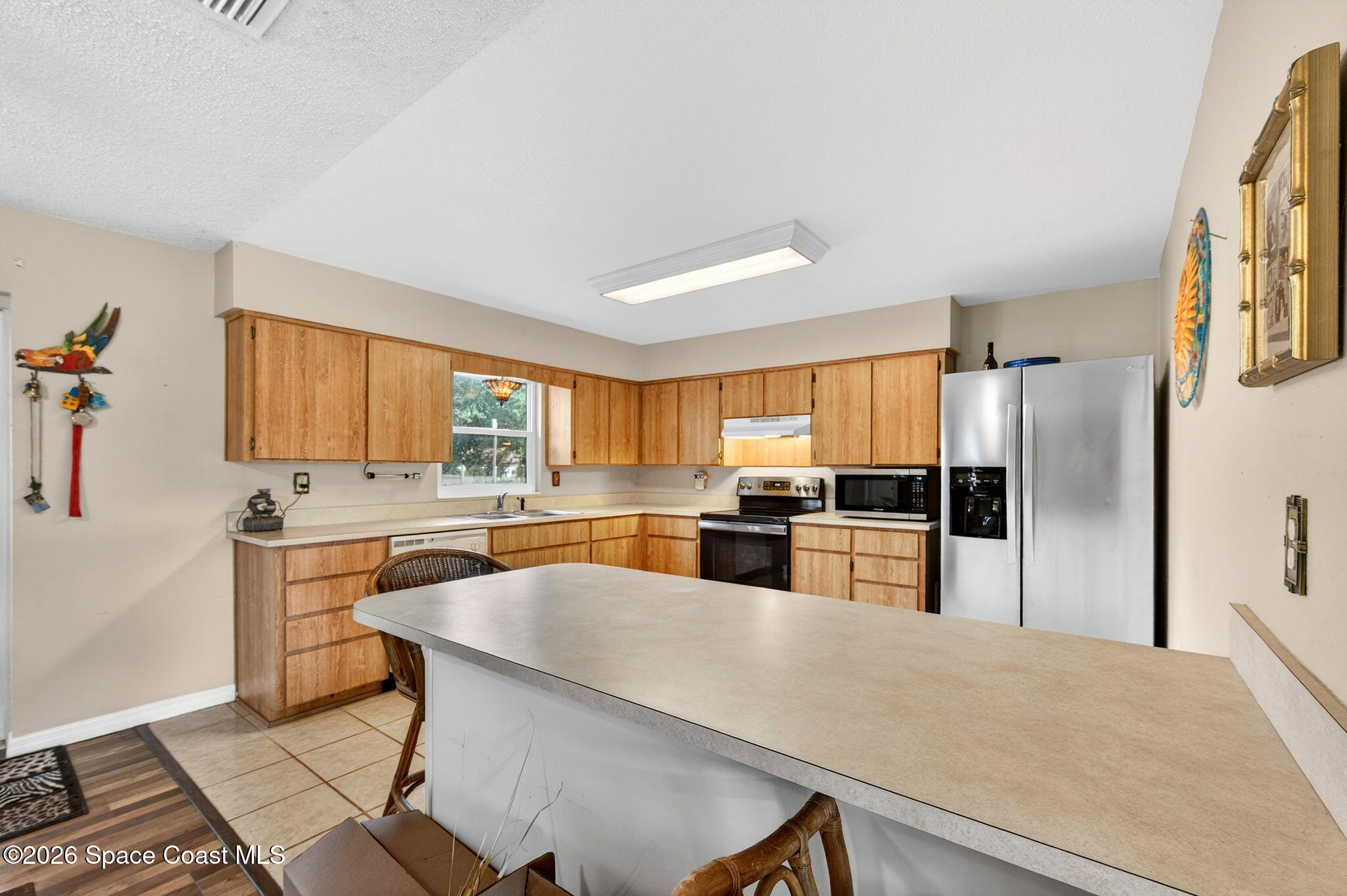 6033 Palm Street Mims, FL 32754 - Photo 18 of 44 a kitchen with stainless steel appliances granite countertop a refrigerator a stove a sink a dining table and chairs with wooden floor