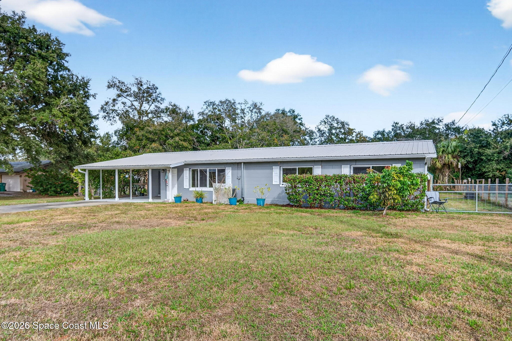 6033 Palm Street Mims, FL 32754 - Photo 2 of 44 a front view of house with yard and trees in the background