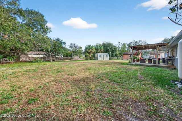 a backyard of a house with lots of green space and fountain