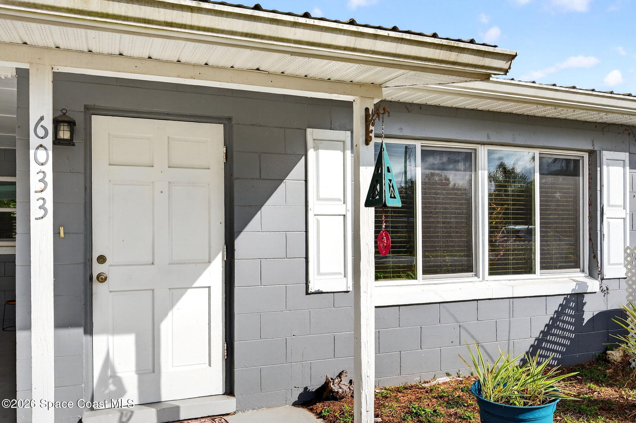 6033 Palm Street Mims, FL 32754 - Photo 4 of 44 a view of a house with a potted plant and a window