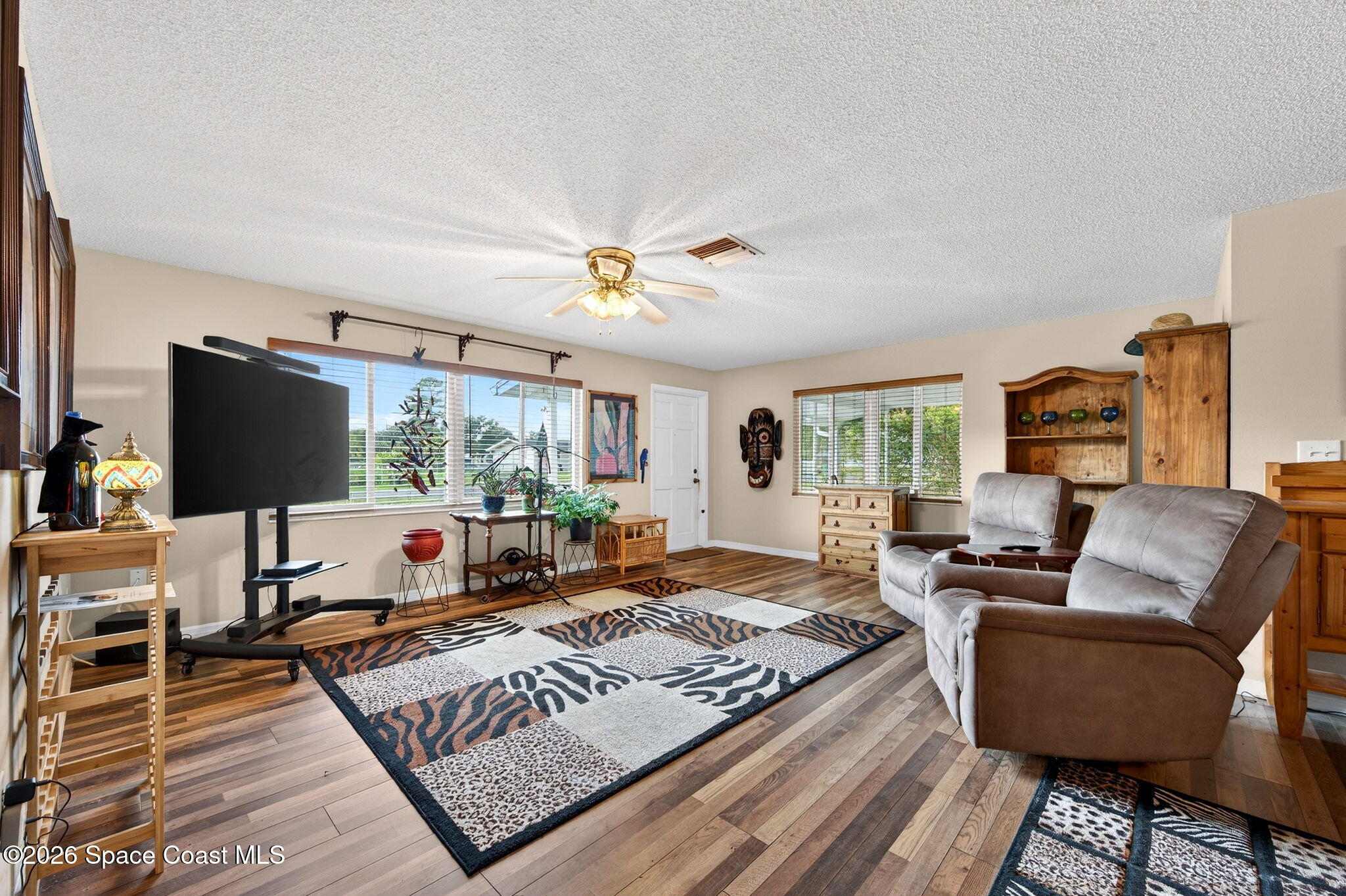 6033 Palm Street Mims, FL 32754 - Photo 8 of 44 a living room with furniture flat screen tv and a large window