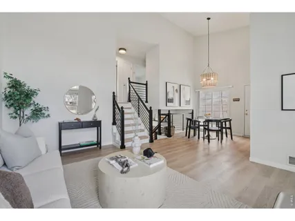 a living room with furniture a wooden floor and a chandelier