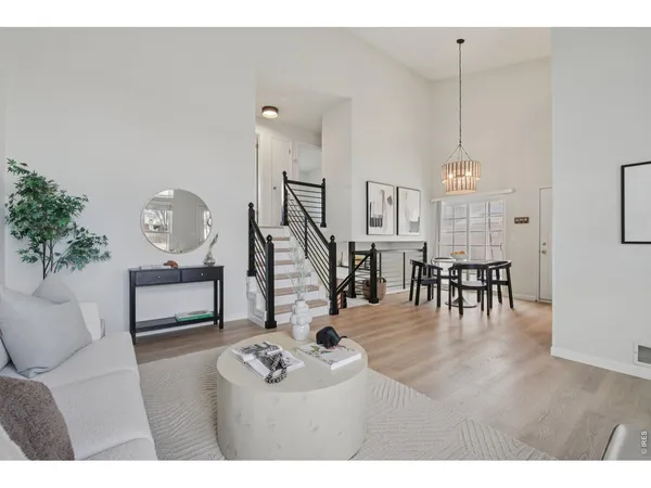 a living room with furniture a wooden floor and a chandelier