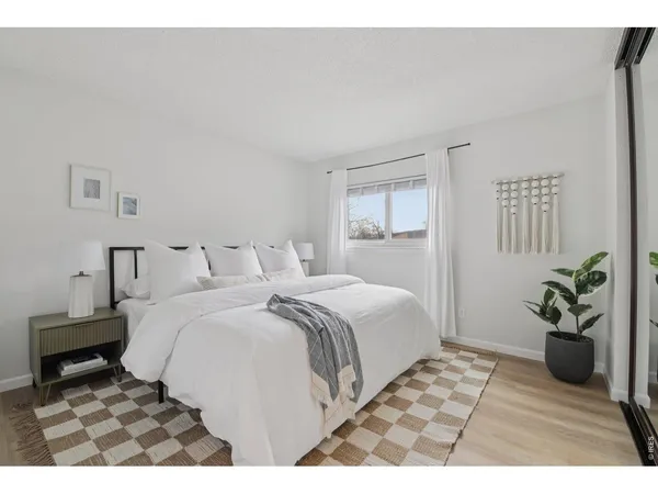 a bedroom with a bed table and a potted plant