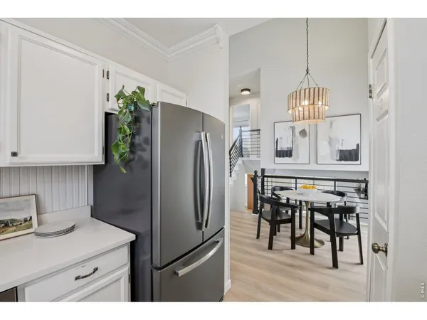 a kitchen with granite countertop a table chairs stove and refrigerator