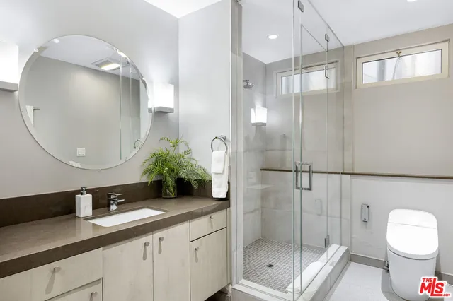 a bathroom with a double vanity sink toilet and shower